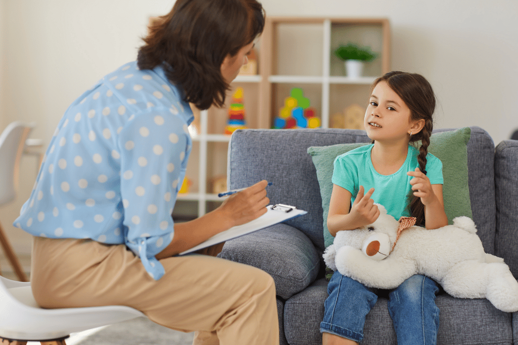 Woman talking with young girl in therapy session