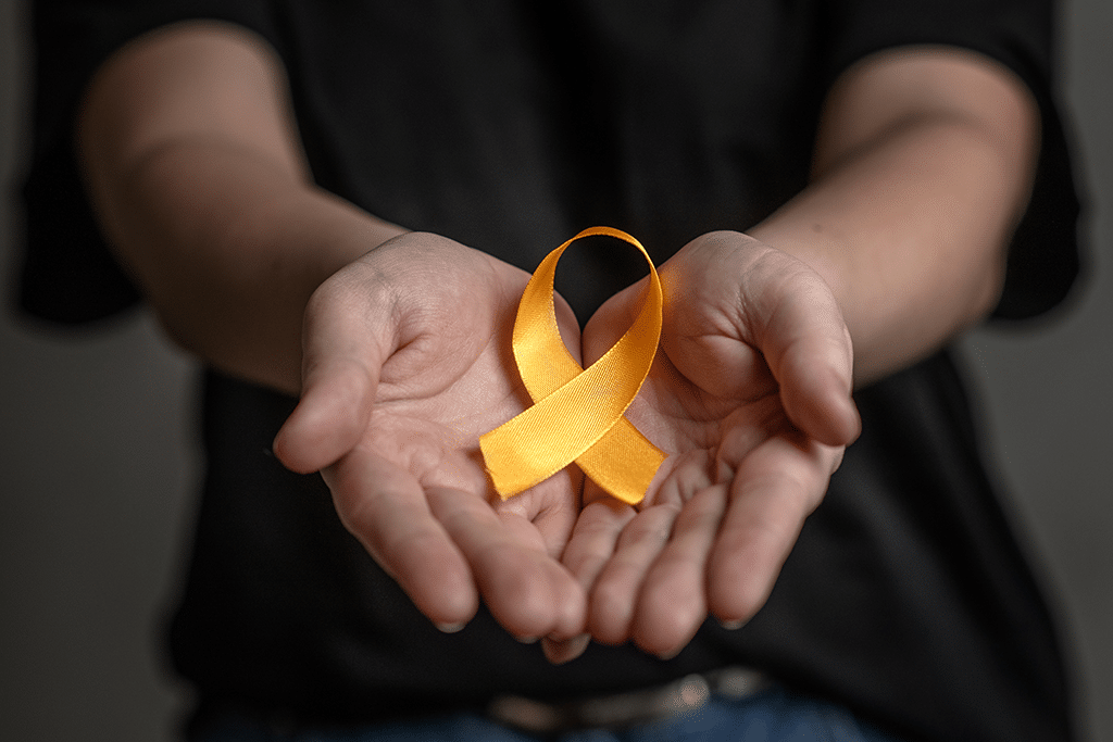 Hands hold yellow ribbon. Concept of suicide and prevention