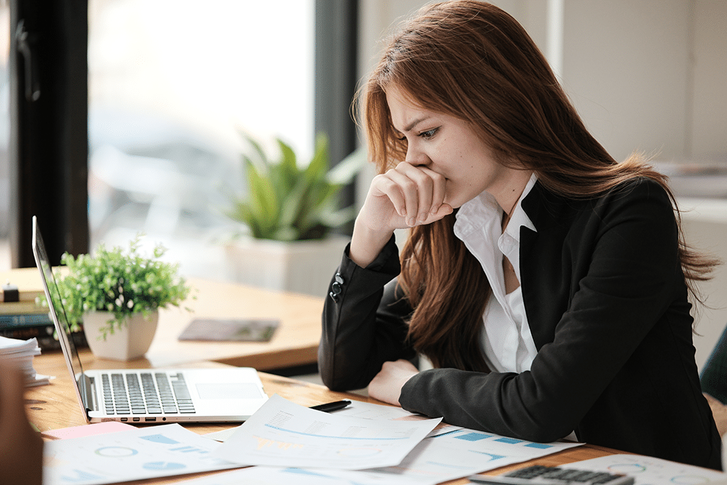 business woman feeling overwhelmed and sad at work desk